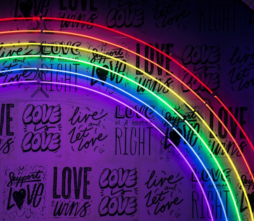 Rainbow led lights with 'love is love' signage in the background Rainbow led lights with 'love is love' signage in the background