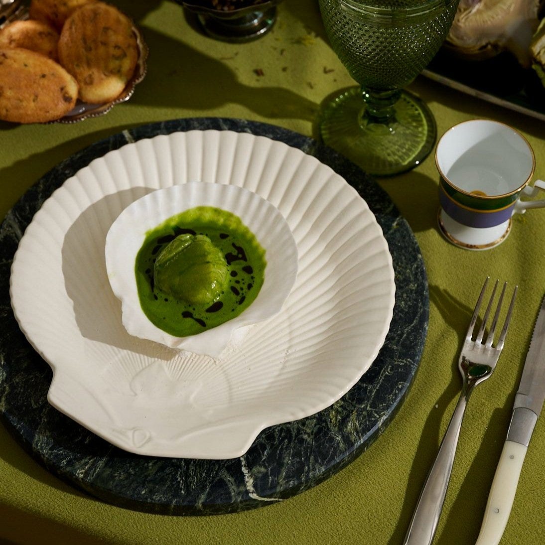 Scallops served in their shells with ramp, green butter, and coriander on a marble charger — main course from the VERTE dinner party menu
