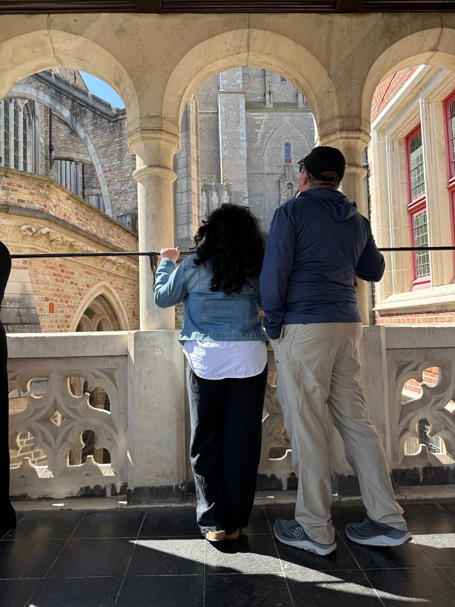 Steve and Rebecca Blackwell looking out onto the town of Bruges, Belgium, from the balcony of a medieval castle.
