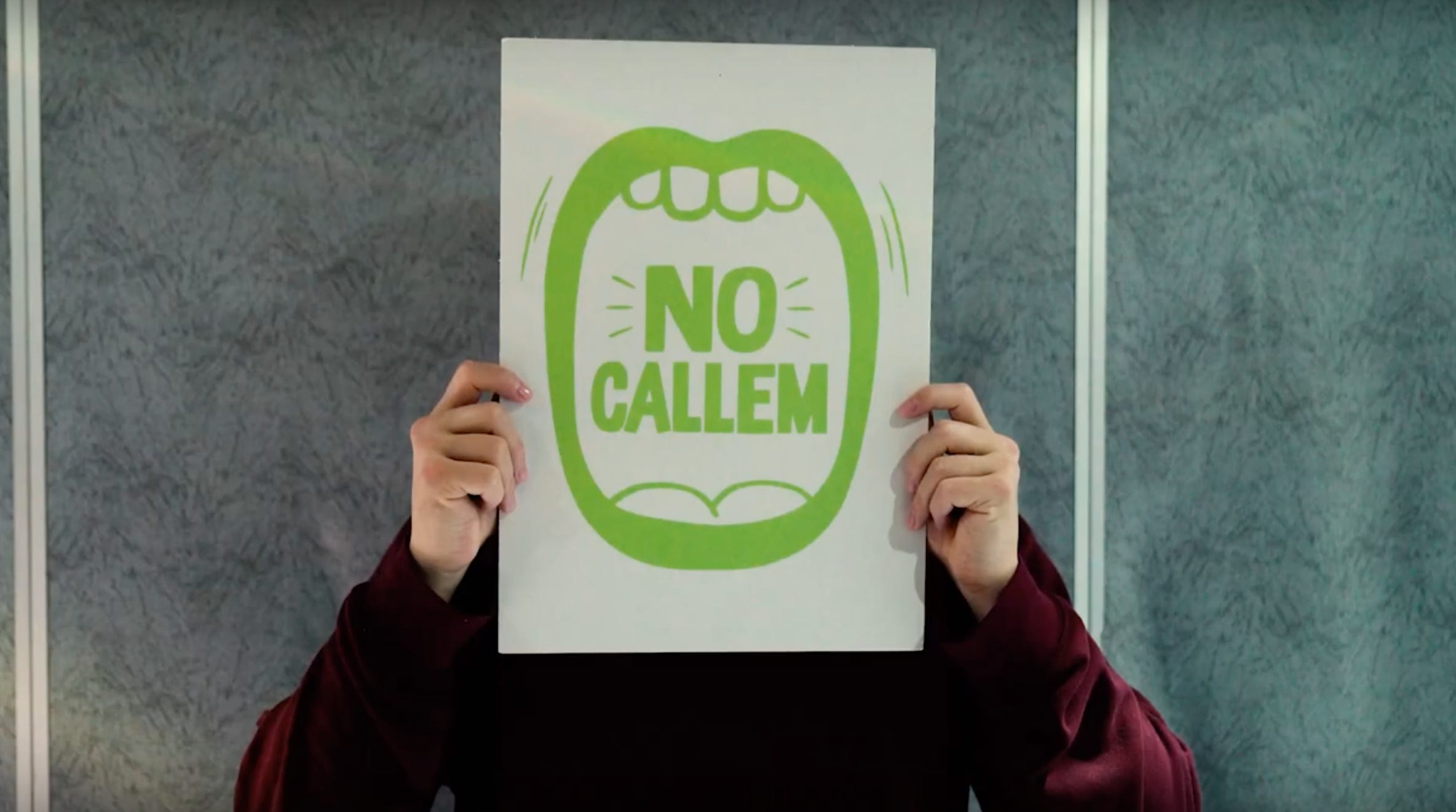 Schermata del video "Barcelona Ciutat Feminista" del comune di Barcellona: un cartello bianco con al centro l'illustrazione verde di una bocca spalancata e le parole NO CALLEM, non stiamo zitte. Schermata del video "Barcelona Ciutat Feminista" del comune di Barcellona: un cartello bianco con al centro l'illustrazione verde di una bocca spalancata e le parole NO CALLEM, non stiamo zitte.