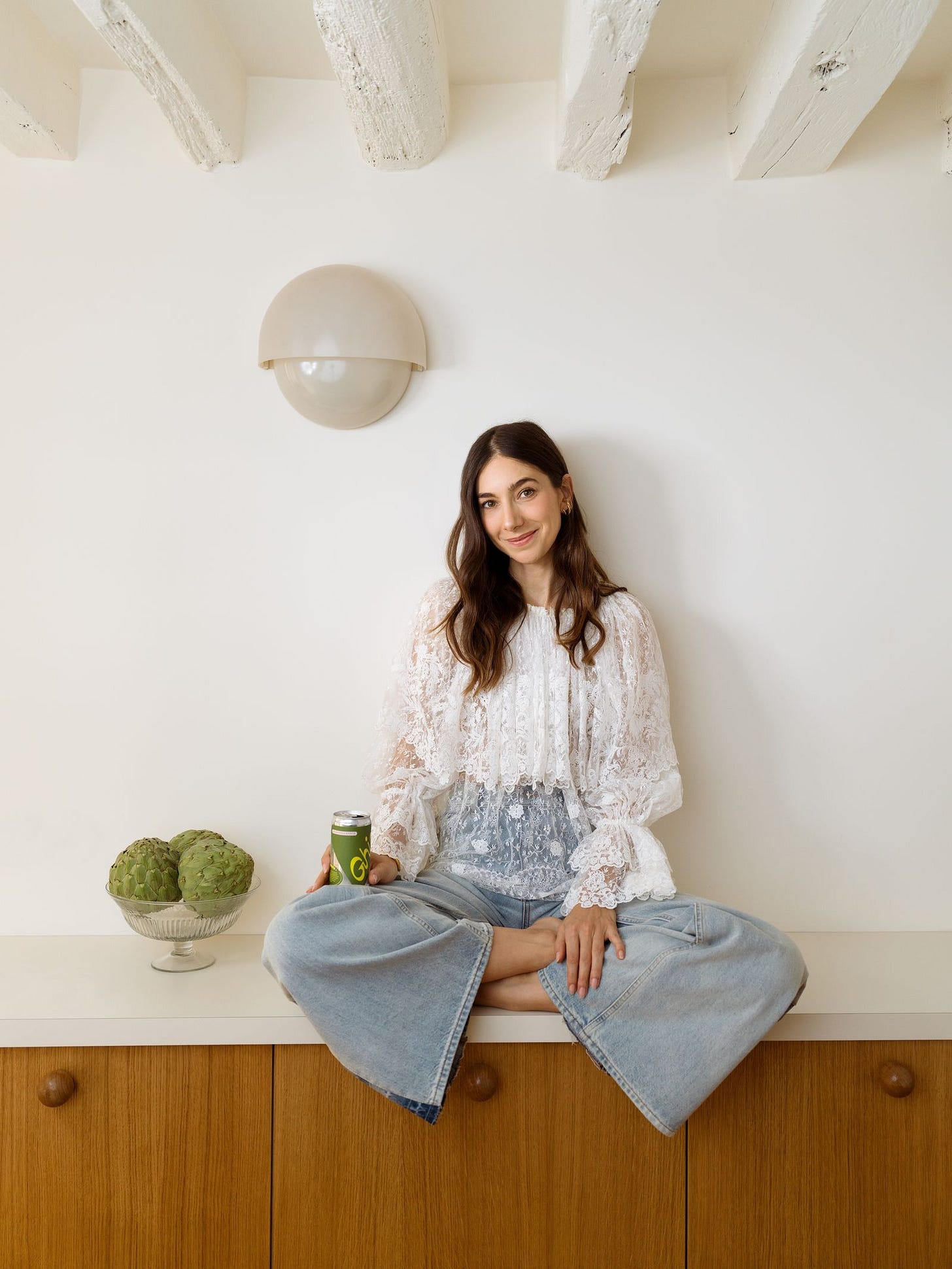 Masarin sits on the kitchen counter with a can of Ghia under a Vico Magistretti sconce. “I love the process. Im dying to...