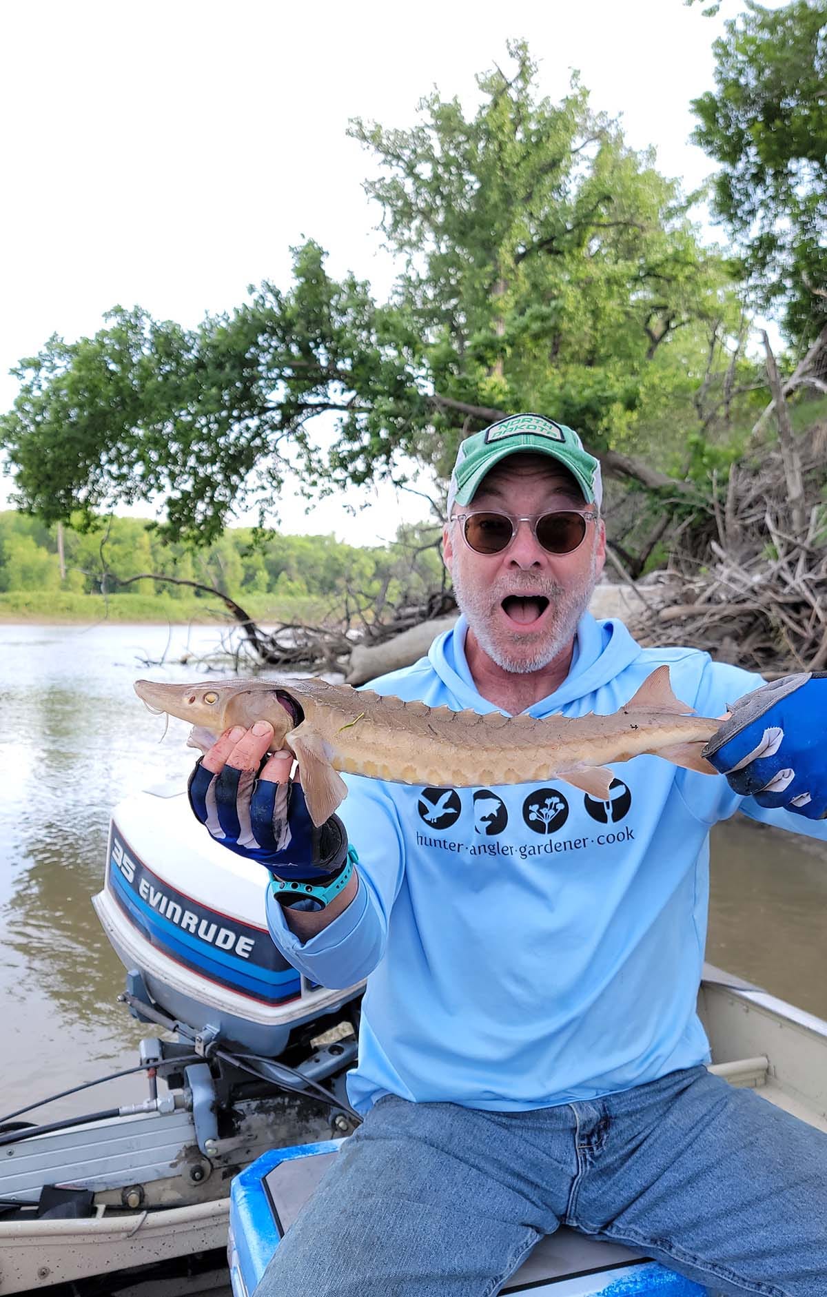 Hank holding a small lake sturgeon. 