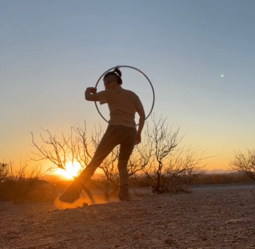 Lyric hoop dancing in the NM dessert sunset, dust flying at their feet