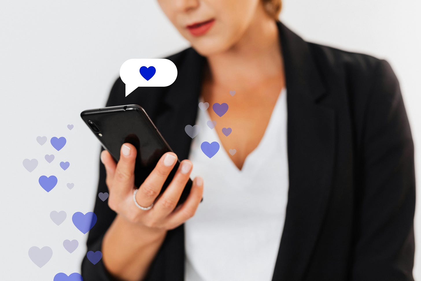 Free Close-up of a woman holding a smartphone with floating heart icons, illustrating digital engagement. Stock Photo