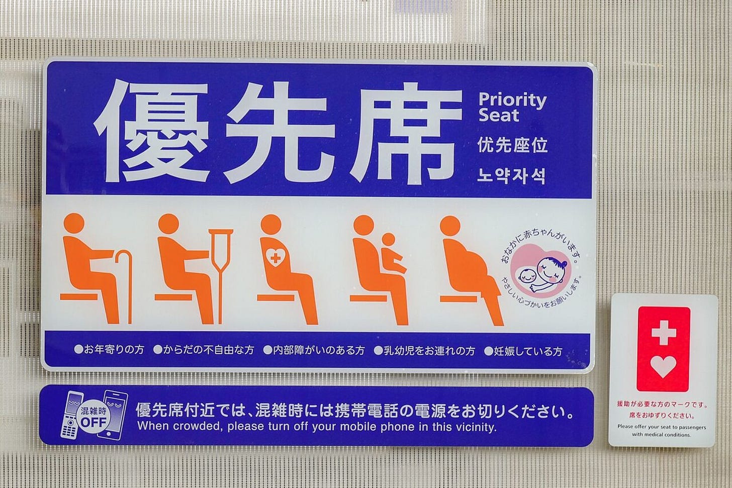 Japanese priority seat sign with icons showing elderly, injured, pregnant people, and a Help Mark symbol indicating support for people with invisible disabilities.