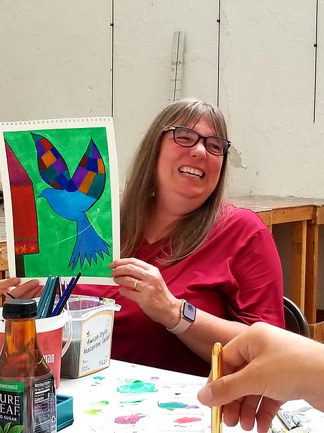 Happy painters holding up their Mary Blair-inspired paintings.