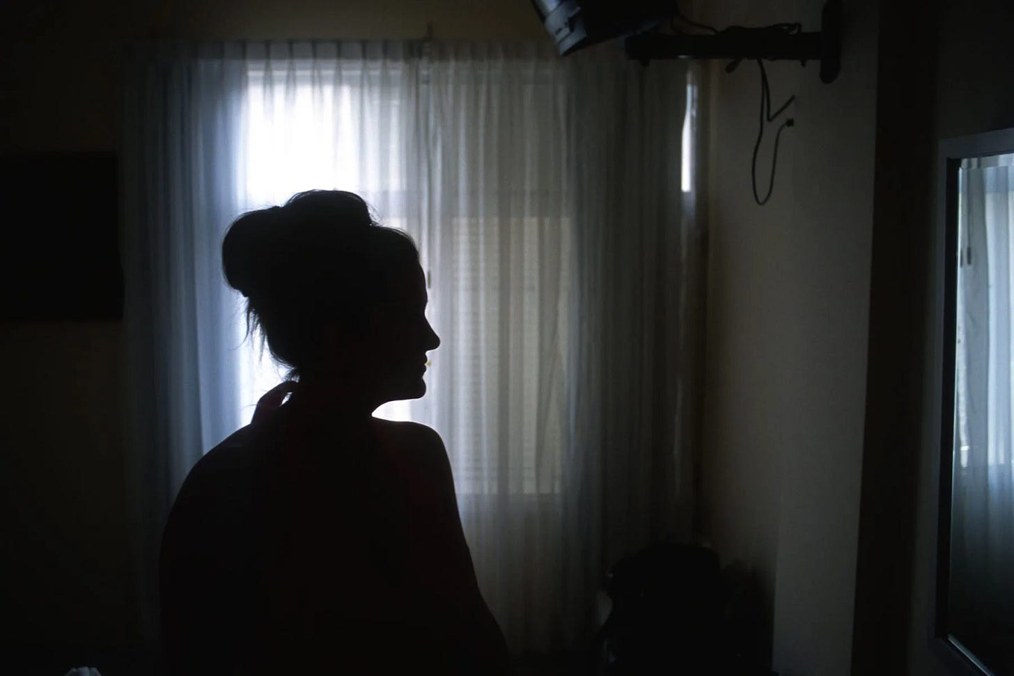 Silhouette of a woman in a room near the window. Silhouette of a woman in a room near the window.