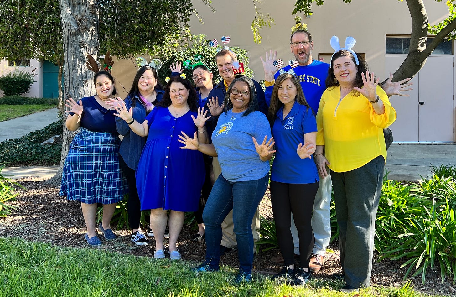 image of group of nine people smiling and wearing silly headbands