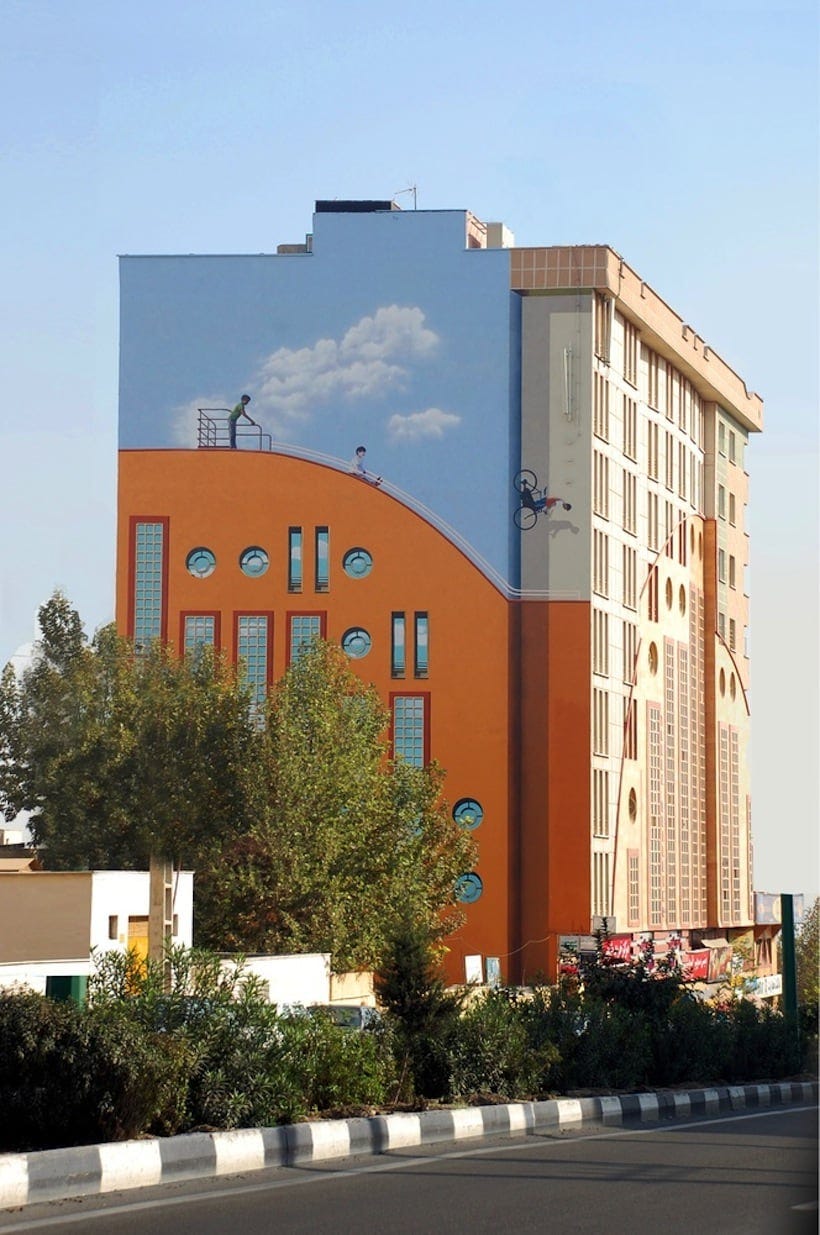 A huge mural showing children plating on a slide on the side of a ten storey building in Tehran by the Iranian artist Mehdi Ghadyanloo.