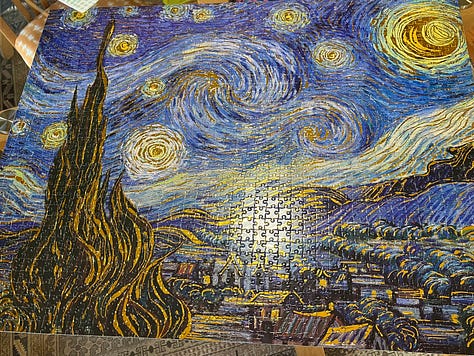 a jigsaw of the vincent van gogh painting starry starry night in various levels of completion. the final photo shows the four duplicate pieces included next to where they matched the puzzle.