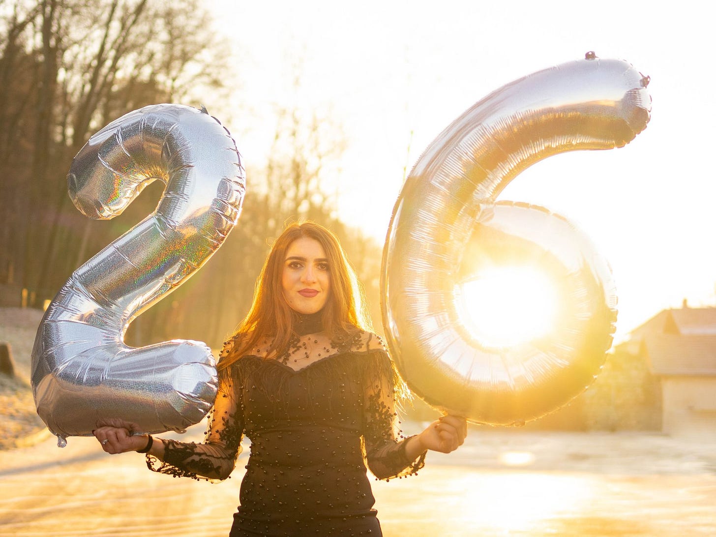 A woman holding balloons spelling 