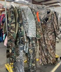 A clothes hanging rack with camo jumpsuits