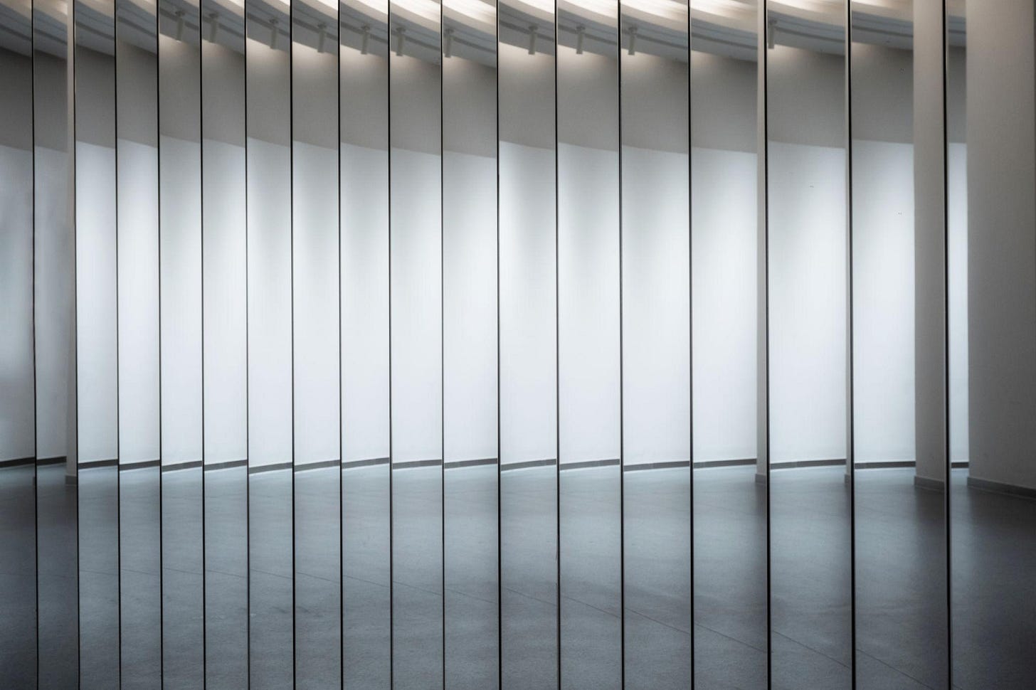 The mirrors of the bright, clean, empty interior buildings reflect