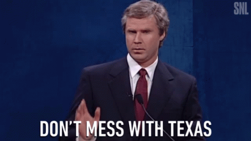a man in a suit and tie speaking into a microphone with the words " do n't mess with texas " below him a man in a suit and tie speaking into a microphone with the words " do n't mess with texas " below him