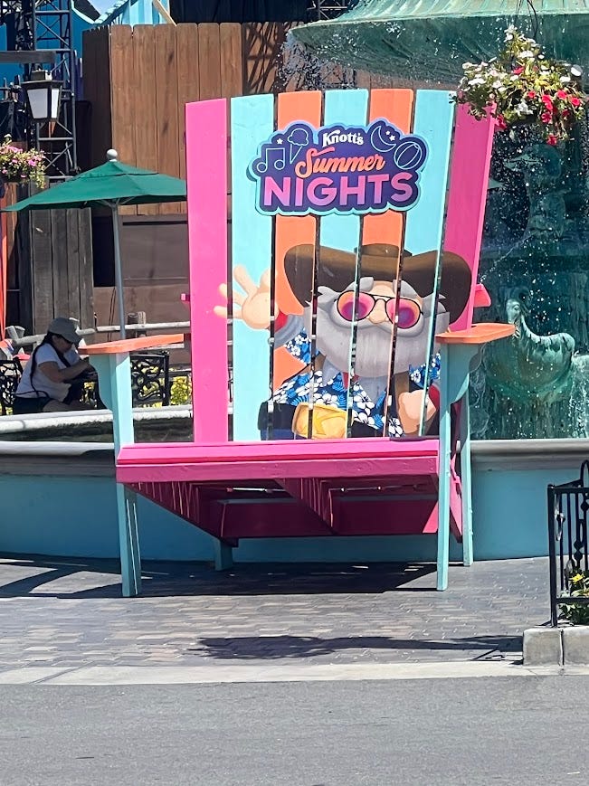 Large chair that says Knott's Summer Nights with a old man with a bushy beard cartoon character. 