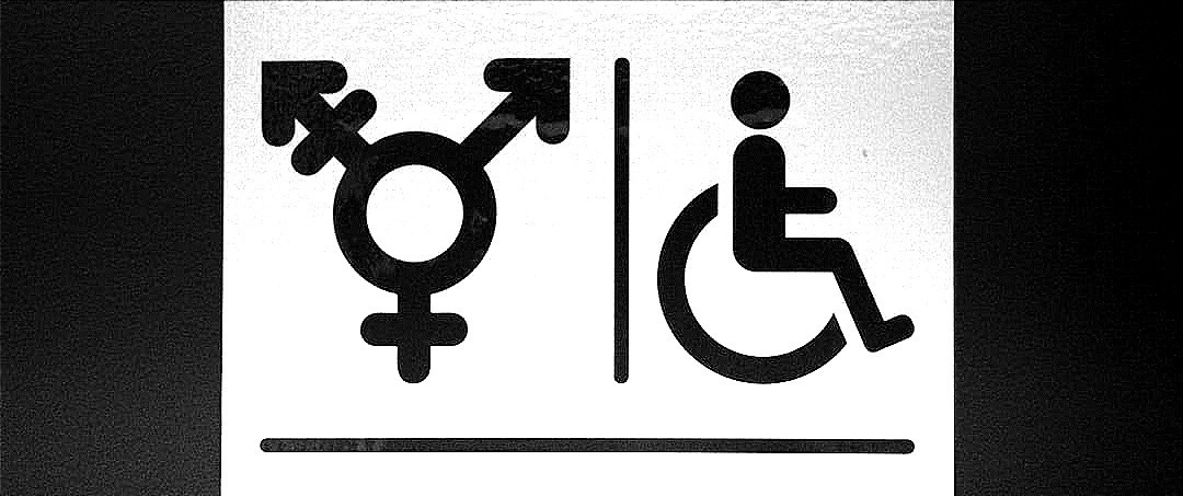 A white sign with a black and white image of a person in a wheelchair