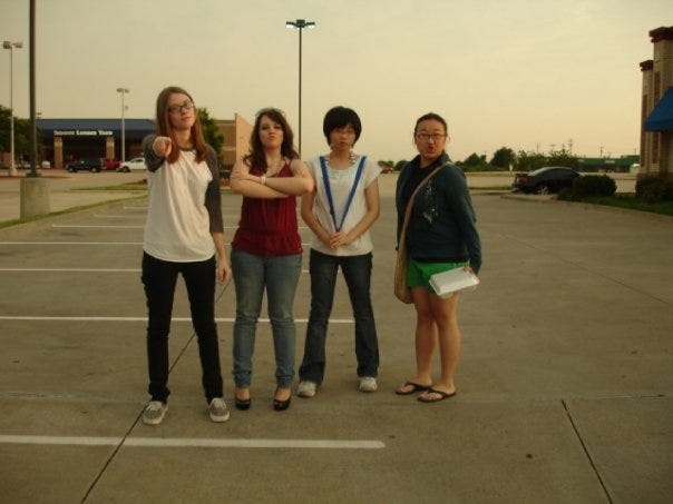 More young soft emo Caley looking disgruntled in front of an American flag or posing in a parking lot with friends.