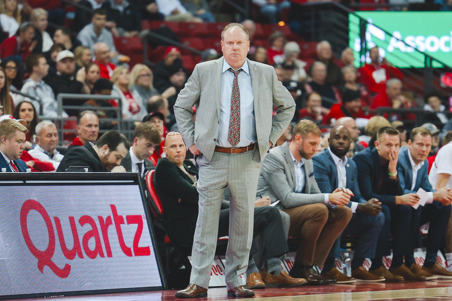 Wisconsin basketball head coach Greg Gard wearing a grey suit and a necktie