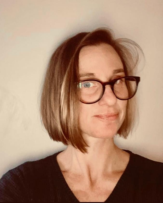 A headshot of Jo Gatford - a 30-something white woman with short blondish hair and glasses.