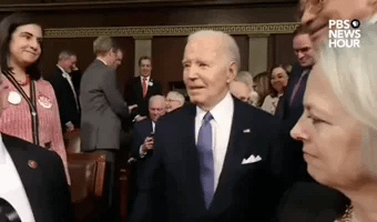 Joe Biden looking surprised at MTG wearing a MAGA hat after the State of the Union