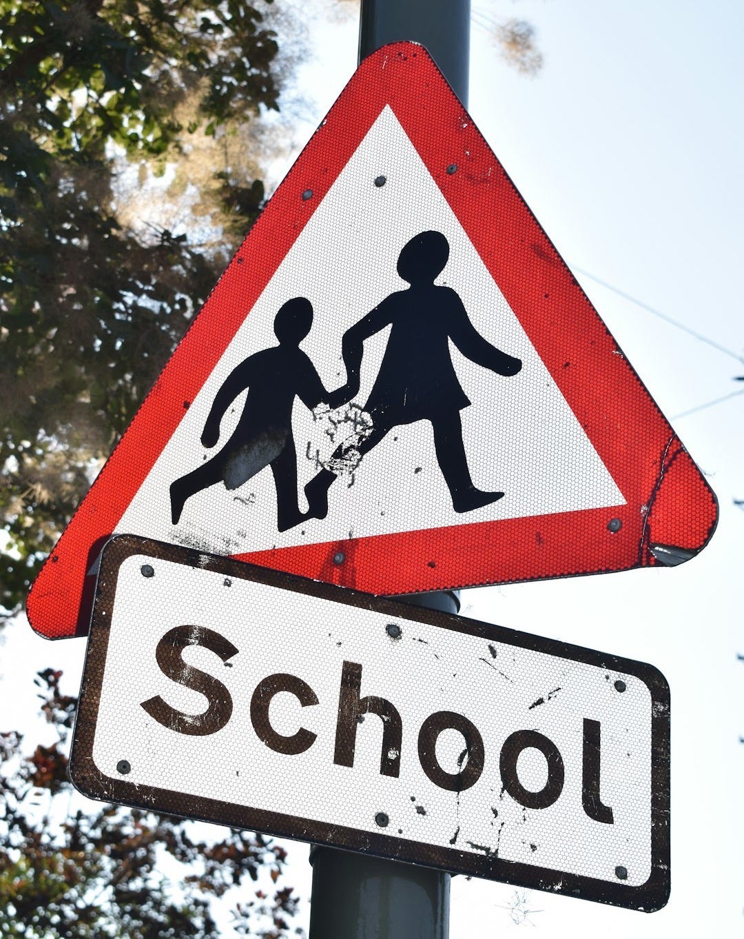 a red and white sign that says school and a black and white sign that says