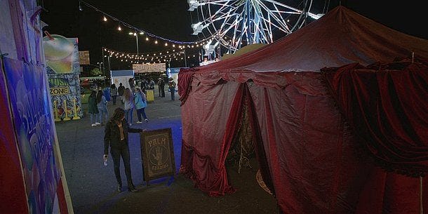 Walker Cassie reading palm readers sign before entering tent at county fair in Dallas. Walker Cassie reading palm readers sign before entering tent at county fair in Dallas.