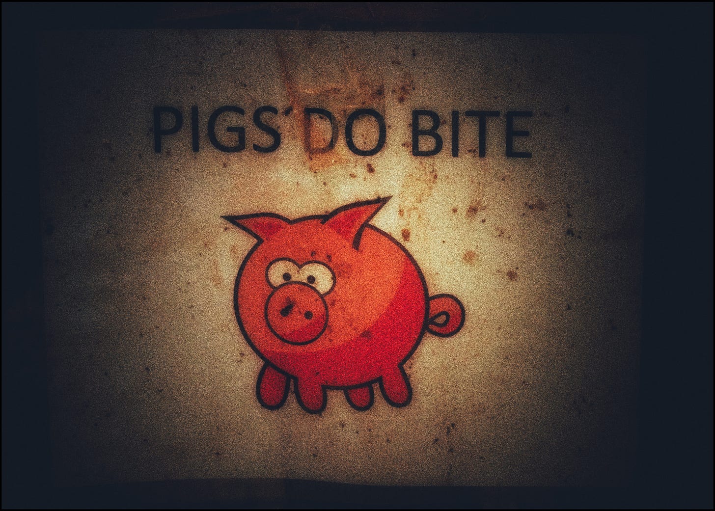 A battered sign depicting the cartoon image of a pig with crossed eyes. The bold lettering above says, “PIGS DO BITE.”