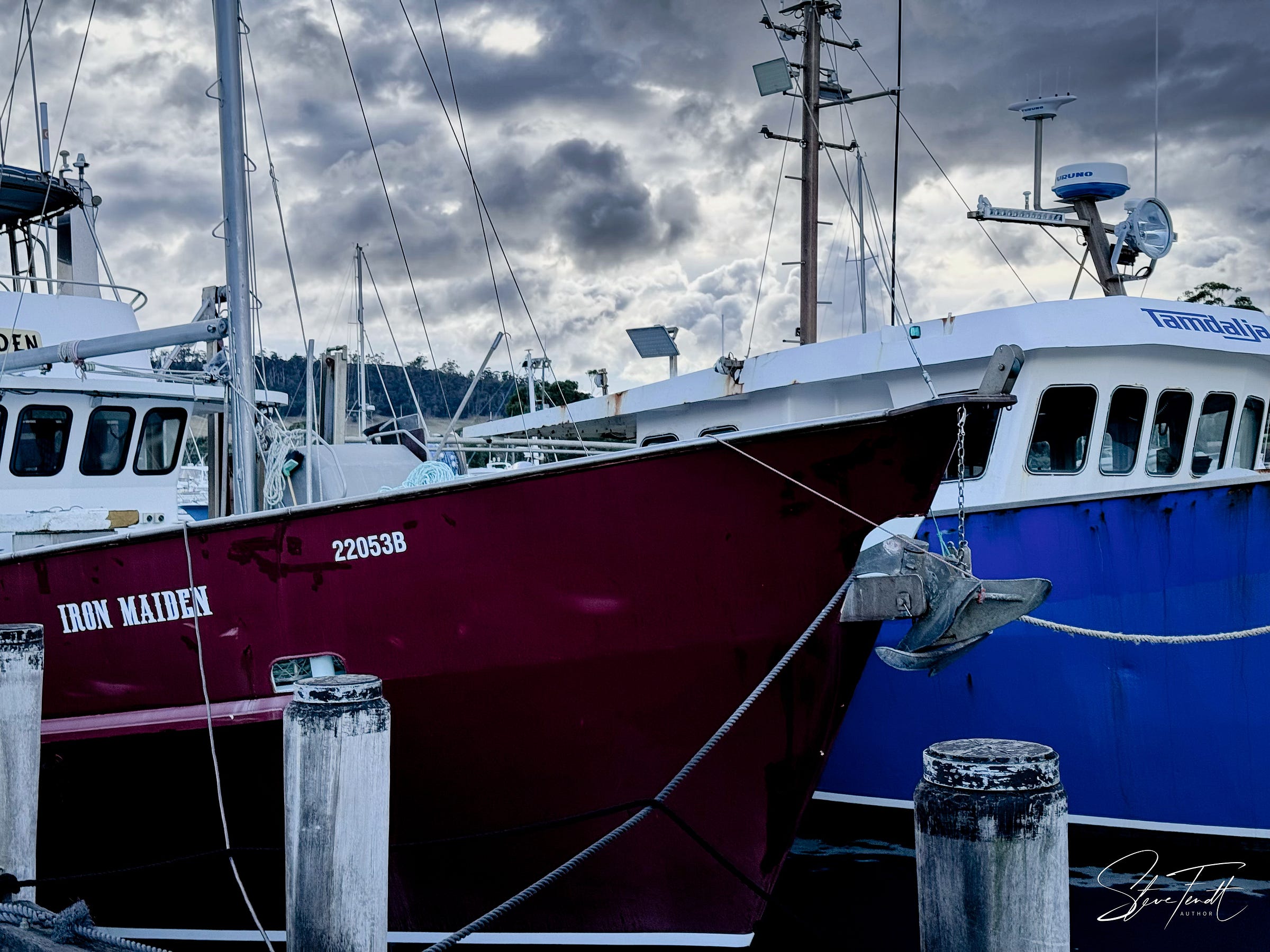 Fishing boats in harbour: a detail of two modern metal trawlers, "Iron Maiden" and "Tamdalja".