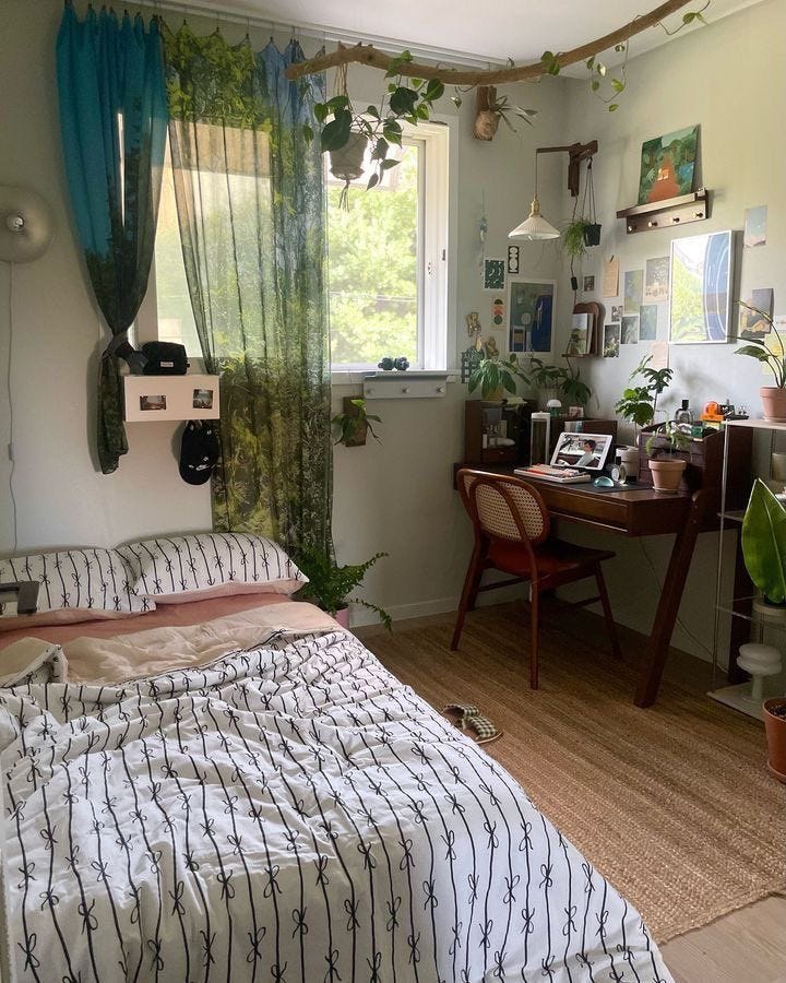 This may contain: a bed sitting in a bedroom next to a desk with a computer on top of it