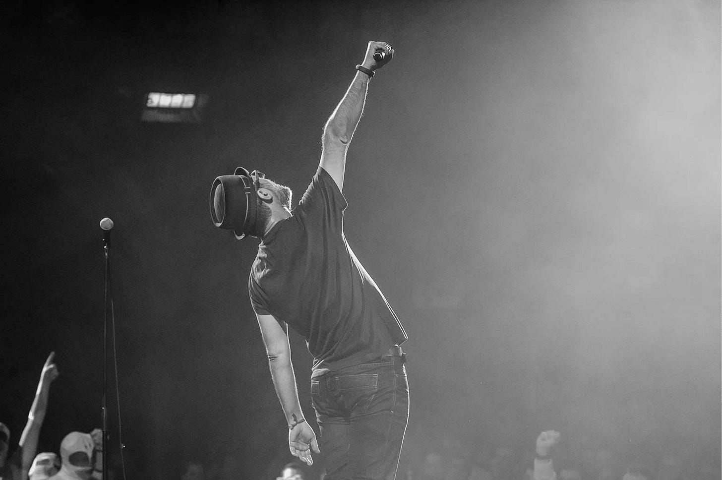 A singer holding up a microphone in trimph A singer holding up a microphone in trimph