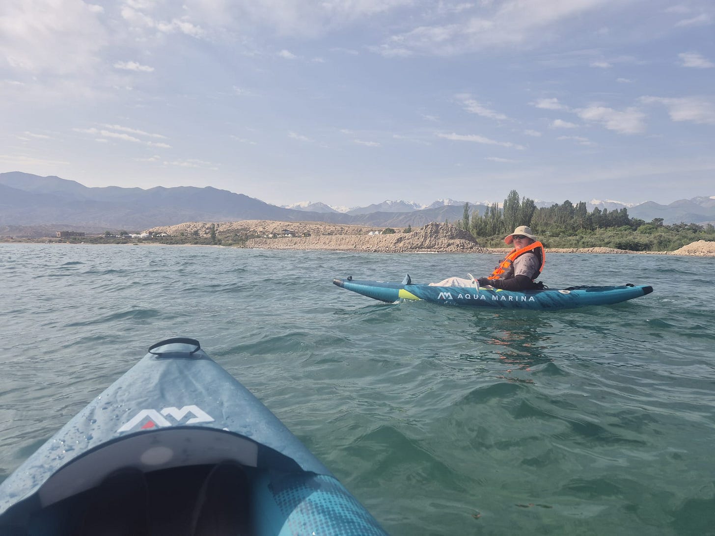 Two woman kayaking along the shores of Issyk Kul lake in Kyrgyzstan.