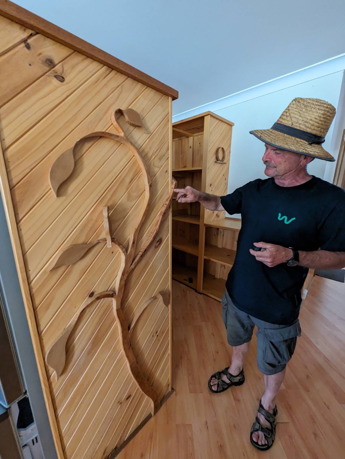 Inside a cabin, Thomas Ebersoll pointing out use of ‘waste’ construction materials.