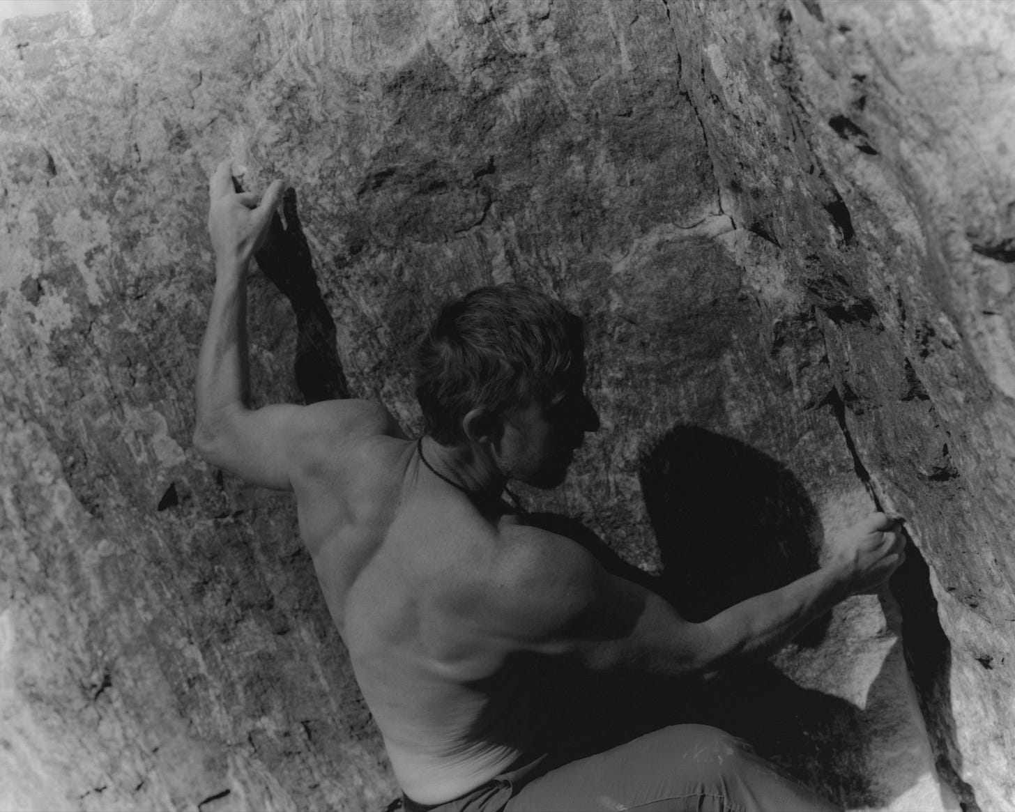 Tommy Caldwell climbing up a cliff.