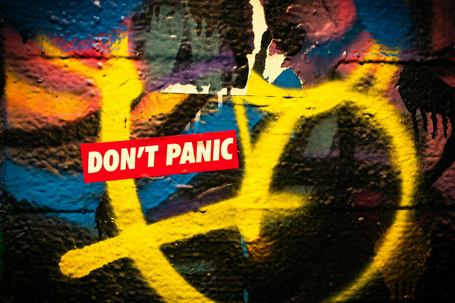 A graffiti wall with a don't panic sign on it A graffiti wall with a don't panic sign on it