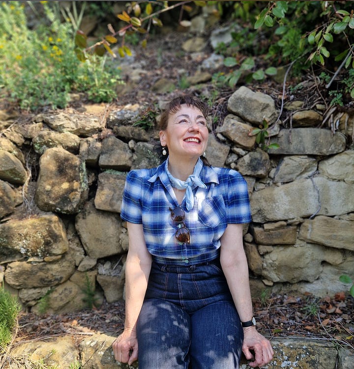 author sandra lawrence in a blue check shirt against a rock wall