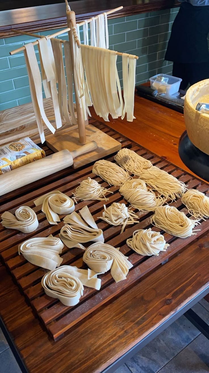 This may contain: there are many different types of pasta on the table and in front of it is a spinning wheel