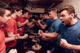 A crowd of NFL fans reacting wildly to a close call on the field.