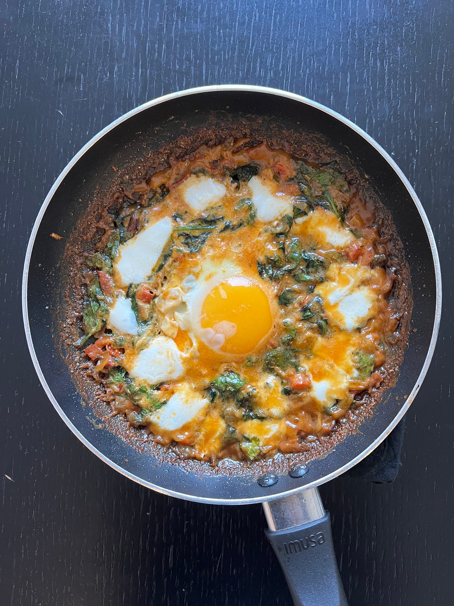 A skillet of rich, tomato-based shakshuka, bubbling with melted mozzarella and a perfectly cooked sunny-side-up egg in the center. The dish includes fresh spinach and herbs, showcasing a blend of textures and Mediterranean flavors. This hearty, comforting meal is part of Foodie Disorder and Liat Portal's culinary journey shared on The Liat Show. A skillet of rich, tomato-based shakshuka, bubbling with melted mozzarella and a perfectly cooked sunny-side-up egg in the center. The dish includes fresh spinach and herbs, showcasing a blend of textures and Mediterranean flavors. This hearty, comforting meal is part of Foodie Disorder and Liat Portal's culinary journey shared on The Liat Show.