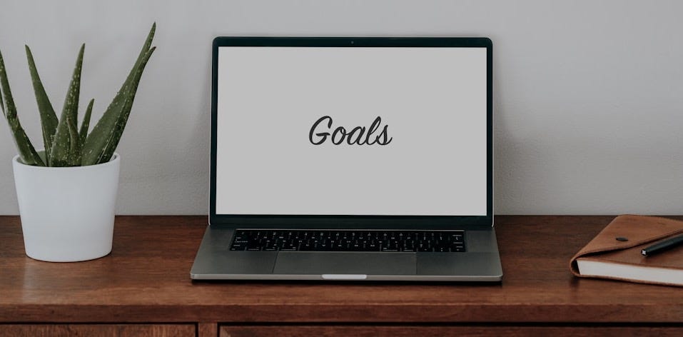 a laptop computer sitting on top of a wooden desk a laptop computer sitting on top of a wooden desk