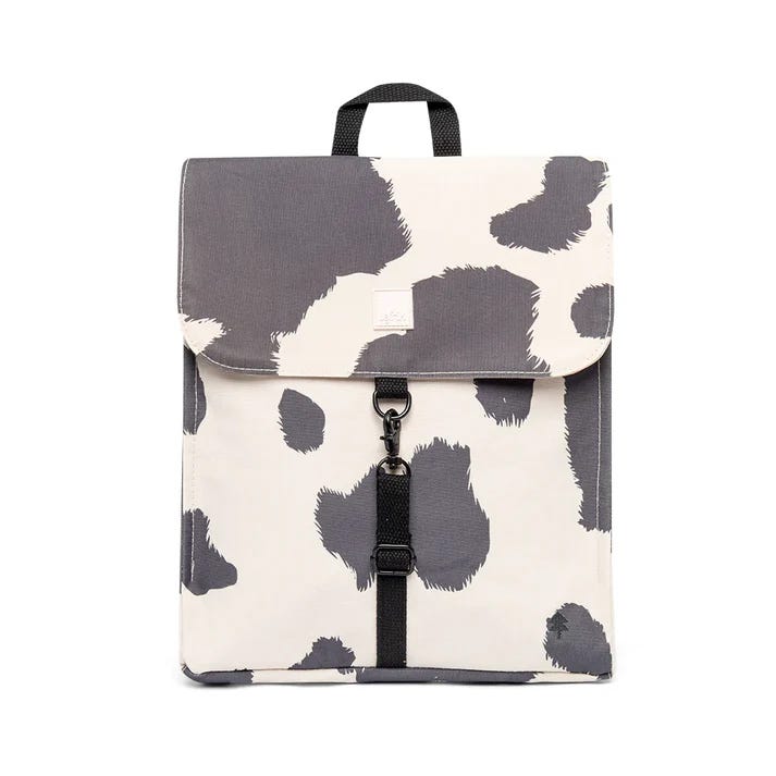 Dos mochilas de los modelos Handy mini y Scout mini de la marca Lefrik con estampado de vaca blanco y negro