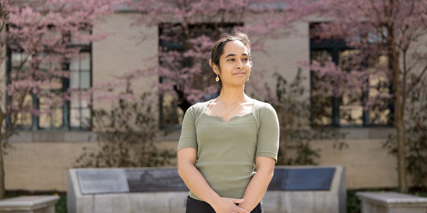 young woman posing in front of a building