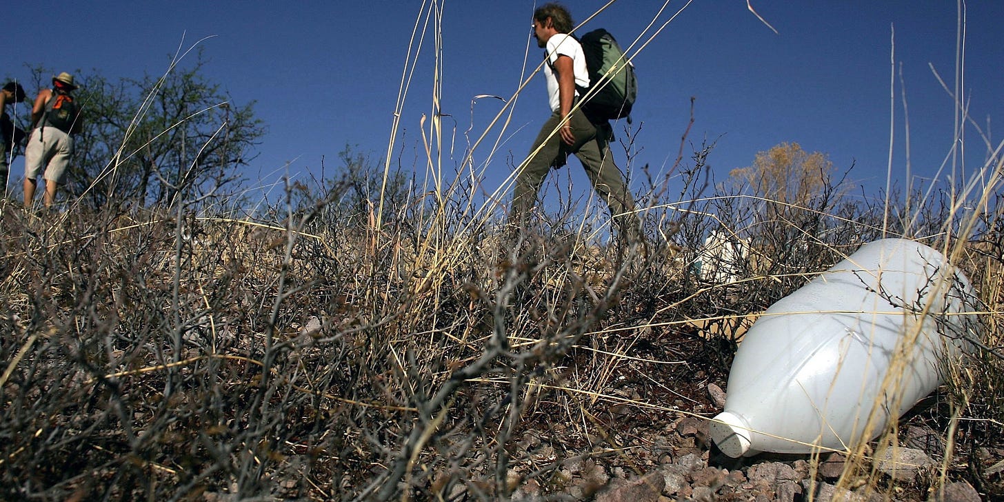PIMA COUNTY, ARIZONA - JUNE 16: Volunteers on patrol with the humanitarian group No More Deaths pass a discarded water jug on a trail used by migrants illegally entering the U.S. from Mexico June 16, 2006 in Pima County, Arizona. Since 1998 over 2,650 men, women and children have died attempting to cross the U.S.-Mexico border. According to the U.S. Border Patrol, a record 473 illegal immigrants died while trying to cross the U.S.-Mexico border during the fiscal year that ended September 30, 2005. No More Deaths runs 24-hour camps in the desert conducting search and rescue patrols for migrants in distress. (Photo by Spencer Platt/Getty Images)