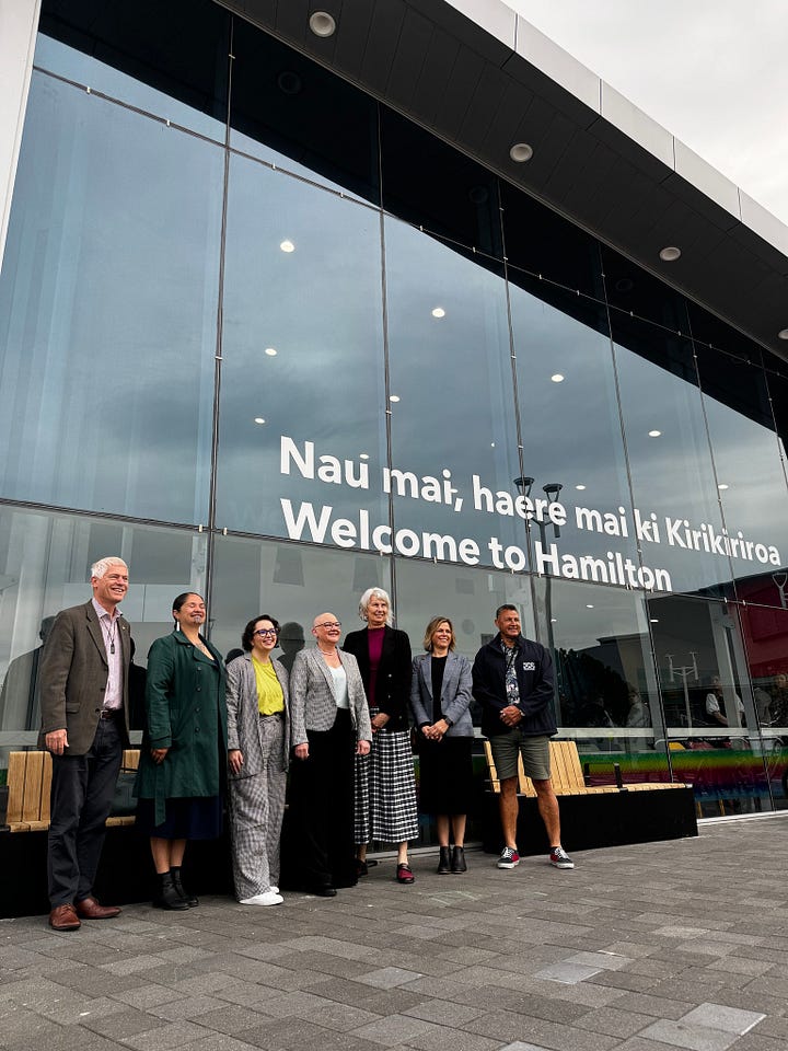 Two photographs from the upgraded transport centre - in front of the new decals on the windows, and one of Louise next to the sculpture they crowd-funded.