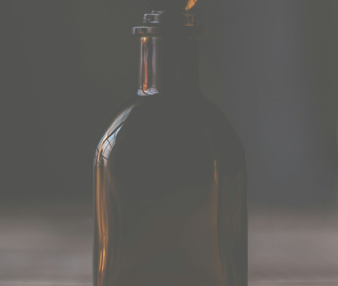 A brown bottle sitting on top of a wooden table