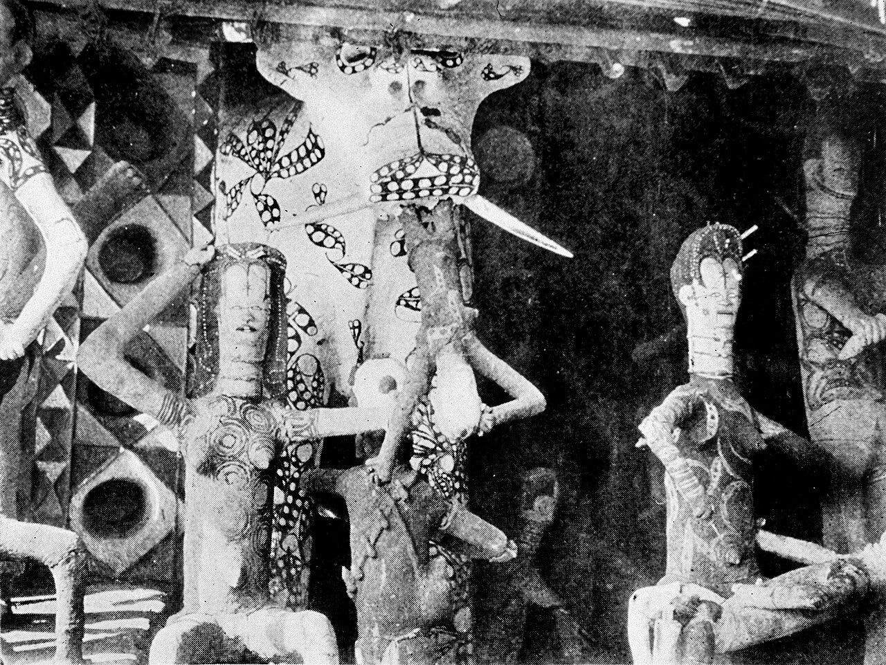 A figure of a hippo swallowing a small human figure, with other figures around it.