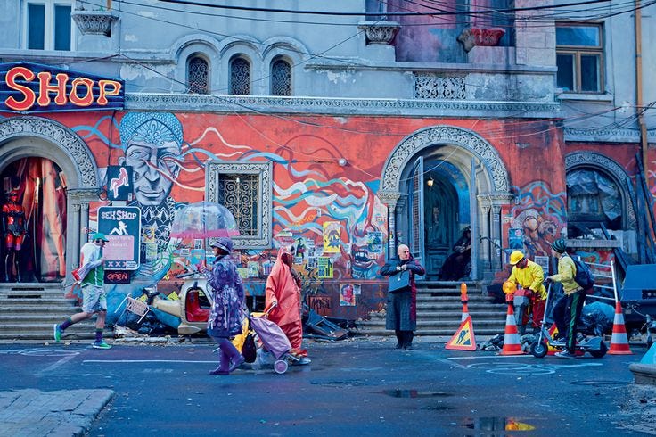This may contain: people walking in front of a building with graffiti on it