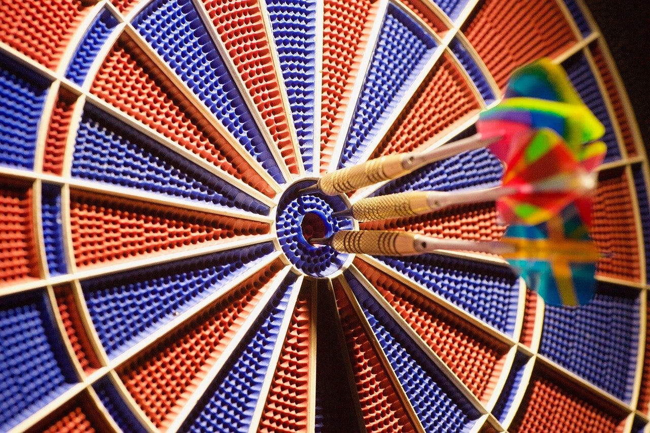 Three darts in a blue and red dartboard
