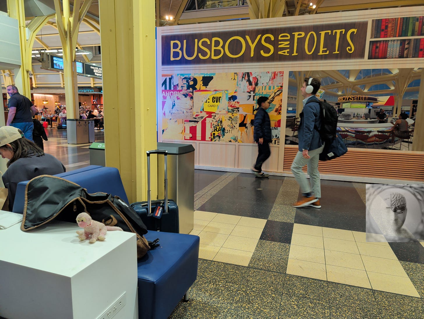 Busboys & Poets storefront in Ronald Reagan International Airport, luggage, travelers passing, dining Busboys & Poets storefront in Ronald Reagan International Airport, luggage, travelers passing, dining