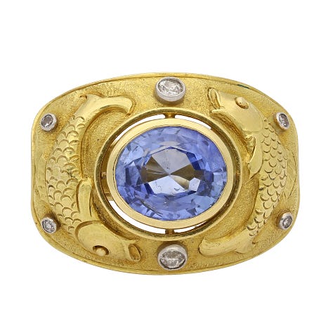 2 rings, one with a colourful green and orange stone, one sapphire, one snake 
