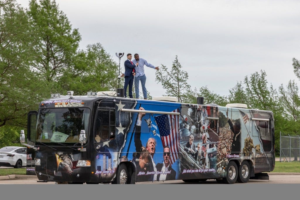 Jake Lang and Philip Anderson deliver a speech from a bus.